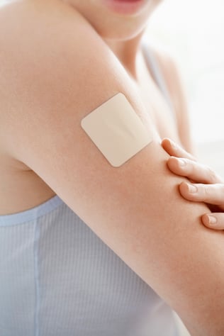 Woman wearing transdermal patch on her arm