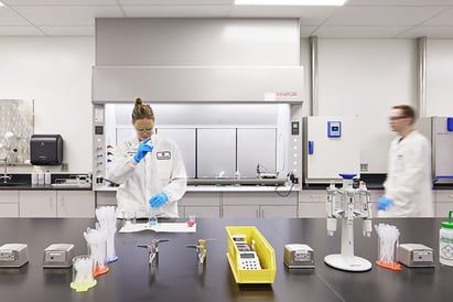 Woman in lab coat mixing formulation